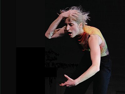 Eine Frau tanzt solo auf der Bühne des Robert-Bosch-Saals